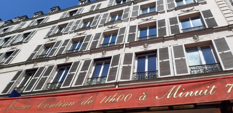 Paris printemps (sous l’enseigne, Damien et Edith conversent)
